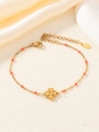 Dettaglio del braccialetto a quadrifoglio con perline rosso corallo e catena d'oro - Rosso anguria