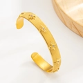 Adjustable golden starburst bangle with brushed texture and zircon star accents - Gold