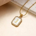 Goldene Halskette mit Buchstabe J, weißer Muschel-Einlage und Zirkonia-Randverzierung - Buchstabe J