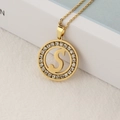 Gold round pendant necklace with paved crystals and hollowed letter S on white surface - S