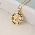 Elegant gold initial V pendant necklace with sparkling zircon pavé on a round disc - Letter U