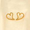 Detalle de los pendientes de corazón hueco irregular en oro sobre tela de seda champán - Corazón Calado Simple (EHF007)
