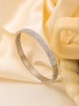 Detailweergave van zilveren roestvrijstalen armband met drie rijen witte zirkonia's - 18K goud / Zilver