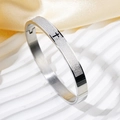 Brazalete de acero plateado pulido con cruz negra y grabado del Padre Nuestro en español - Acero Mayúsculas