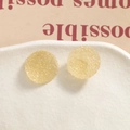 Macro shot of yellow sugar-ball resin beads with crystalline texture on a white plate - Beige