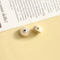 Macro detail of ivory glass evil eye beads showing side hole for DIY jewelry making - Light Coffee Round / 1 Piece