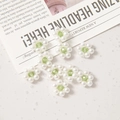 Detailed view of 12mm white pearl flower beads with a green crystal center for DIY jewelry - Green