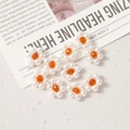 Detailed view of handmade 12mm woven flower beads with white pearls and orange crystals - Orange
