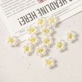 Detailed close-up of DIY daisy flower charms made of white pearls and yellow crystal beads - Yellow