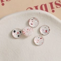 Detail showing five 10mm glass cabochons with artistic red and black ink splatter patterns - White