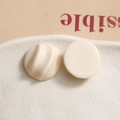 Detailed macro view of chic cream resin semi-circle charms with spiral textures - White