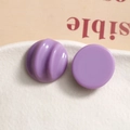 Macro view of chic purple resin stud earrings featuring smooth and wavy textured surfaces - Deep purple