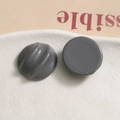 Detail of dark gray resin semi-circle resin charms with smooth and spiral textured surfaces - Gray
