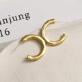 Detailansicht der matten goldenen C-Ohrringe mit gehämmerter Metallstruktur und Silberstiften - C-Form Stil