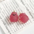 Vue macro de pendentifs fantômes en résine rose translucide avec paillettes dorées DIY - Poupée Noeud Scintillant Rose (2)