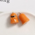 Vue macro de breloques fantômes en résine orange avec crochets en métal doré sur plat - Style de Fantôme Orange Expressif (4)