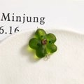 Macro shot of a matte green glass flower bead with silver jump ring for DIY jewelry making - Green