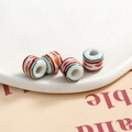 Detailed view of four colorful striped ceramic beads for DIY jewelry making and crafts - 10x9mm