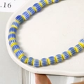 Dettaglio ravvicinato di perline di zucca in ceramica 9x7mm per gioielli fai-da-te - Blu e Giallo
