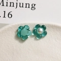 Vue macro de breloques fleurs en résine bleue avec perle pour création de bijoux - Vert Lac