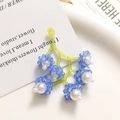 Macro detail of handmade floral bead earrings with blue faceted crystals and white pearls - Blue