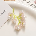 Detailed view of handmade pink lily of the valley beaded earrings on a white plate - Pink