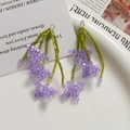 Détail de boucles d'oreilles fleurs en perles violettes sur un plateau blanc épuré - 1 Pièce / Violet