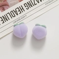 Macro detail of plush purple peach resin charms with soft flocking and green leaves - Purple