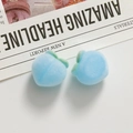 Detailed close-up of light blue flocked peach charms with green leaves on white background - Blue