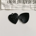 Detailed macro view of heart-shaped gothic alloy charms with relief and sunburst textures - All Black Style (L03-3-16)