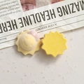 Macro shot of flocked yellow sun resin charm with pink bow for DIY jewelry making - Sun