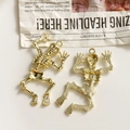 Macro detail of golden metal skeleton charms for Halloween DIY jewelry making - Gold