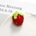 Detailed close-up of a handmade 3D knitted strawberry with green leaves and white seeds - Strawberry Shape