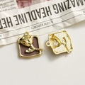 Detailed close-up of vintage golden rose pendants with purple enamel and textured back - Chocolate Square Gold Rose