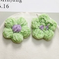 Detail of handmade plush puff flower with green petals and purple core for DIY crafts - Green