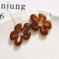 Detailaufnahme brauner Blumenanhänger aus Harz auf einer strukturierten Steinplatte - Bernstein