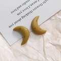 Detailed shot of crescent resin earrings in mustard yellow with gold star patterns - 3D Style
