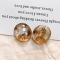 Macro-opname van ronde amberkleurige harsbedels met goudfolie en witte marmerstructuur - Bruin