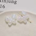 Macro shot of white pearlescent butterfly beads with gold pins for DIY jewelry making - 1 Piece / White