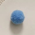 Macro-opname van een lichtblauwe handgemaakte DIY pluchen pompon met zachte textuur - Hemelsblauw