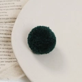 Macro-opname van een donkergroene pluizige pompon voor DIY-sieraden en decoraties - Zwart Groen