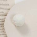 Macro-opname van een witte pluizige pompon voor DIY-ambacht op beige schotel - Wit