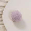 Close-up van een zachte lavendelkleurige gebreide pompon voor DIY-sieraden en accessoires - Lichtpaars