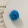 Gedetailleerde close-up van een felblauwe wollen pompon voor DIY-knutselaccessoires - Saffierblauw