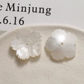 Macro detail of white acetate flower pendants with shell texture and central hole - White
