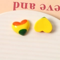 Vista dettagliata di ciondoli in resina a forma di cuore colorati su un piatto di ceramica - Cuore Giallo
