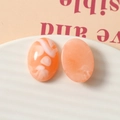 Vue macro de cabochons ovales en résine avec effet marbré orange et blanc pour DIY - Orange
