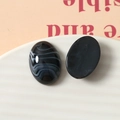 Vue macro de cabochons ovales en résine noire avec texture de marbre blanc sur plat - Noir