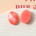Gros plan détaillé sur des cabochons ovales en résine marbrée corail pour bijoux DIY - Rouge pastèque