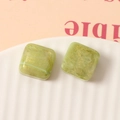 Nahaufnahme von 16mm quadratischen grünen Harzperlen mit Marmortextur und Goldglitzer - Matcha-Grün